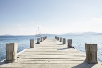 Empty jetty and saling boat — Stock Photo