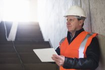 Hombre usando la tableta en el edificio en construcción - foto de stock