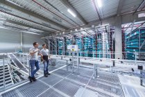 Hombres de pie en el almacén de alto rack - foto de stock