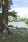 Mann mit Notizbuch sitzt im Park — Stockfoto