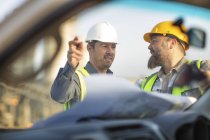 Travailleurs des carrières vérifiant le plan du site — Photo de stock