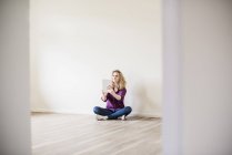 Donna seduta sul pavimento e che utilizza tablet — Foto stock