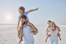 Família passeando na praia — Fotografia de Stock