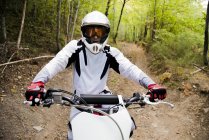 Motocross biker riding in forest — Stock Photo