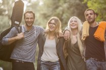 Four happy friends walking on path — Stock Photo