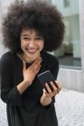 Retrato de mujer joven riendo con teléfono inteligente - foto de stock