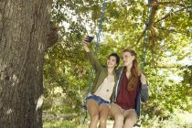 Amici di sesso femminile su swing prendere selfie — Foto stock