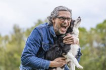 Homme câlin chien — Photo de stock