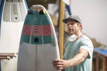 Surfshop empregado admirando prancha — Fotografia de Stock