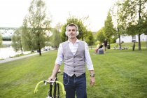 Hombre de negocios con bicicleta y auriculares - foto de stock