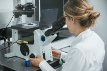 Técnico usando microscópio em laboratório — Fotografia de Stock