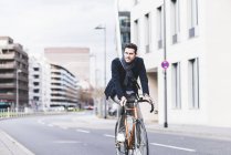 Businessman riding bicycle — Stock Photo