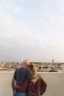 Paar umarmt sich und blickt auf Stadtbild — Stockfoto