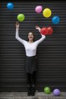 Mujer de pie con globos voladores - foto de stock