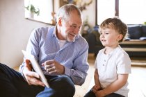 Grandfather and grandson using tablet — Stock Photo