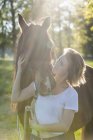 Женщина и лошадь стоя на природе — стоковое фото