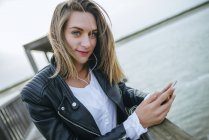Junge Frau mit Smartphone und Kopfhörer — Stockfoto