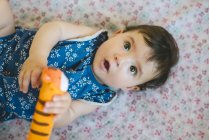 Девочка играет с игрушкой-тигром — стоковое фото