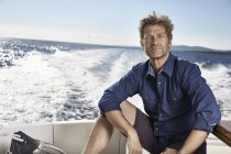 Uomo maturo seduto su yacht a motore — Foto stock