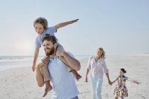 Família passeando na praia — Fotografia de Stock