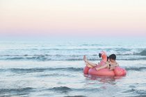 Couple flottant avec flamant rose gonflable — Photo de stock