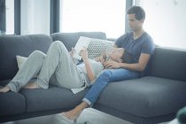 Casal com tablet relaxante em casa — Fotografia de Stock