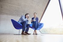 Uomo e donna seduti sulle sedie in ufficio — Foto stock