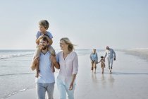 Família passeando na praia — Fotografia de Stock
