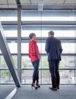 Geschäftsmann und Geschäftsfrau reden am Fenster — Stockfoto