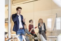 Uomo d'affari con cellulare in ufficio — Foto stock