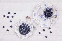 Tasse und Teller mit Blaubeeren — Stockfoto