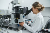 Técnico usando microscópio em laboratório — Fotografia de Stock