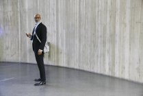 Uomo d'affari con borsa con smartphone — Foto stock