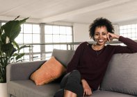 Woman sitting on couch — Stock Photo