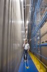 Man in passageway in a factory talking on cell phone — Stock Photo