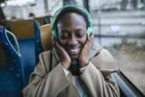 Donna che ascolta musica in autobus — Foto stock