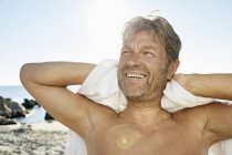 Uomo con asciugamano di fronte al mare — Foto stock