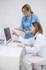 Médecins regardant moniteur d'ordinateur — Photo de stock
