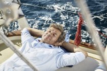 Uomo maturo sdraiato sul ponte — Foto stock