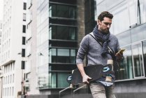 Man carrying skateboard — Stock Photo