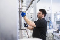 Hombre trabajando en planta de fábrica - foto de stock