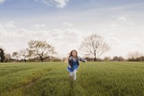 Девушка бежит по зеленому газону — стоковое фото