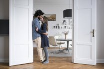 Целующая пара, стоящая в дверной раме — стоковое фото