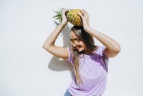 Young woman holding pineapple — Stock Photo