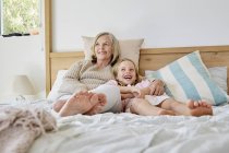 Mädchen liegt mit Großmutter im Bett — Stockfoto