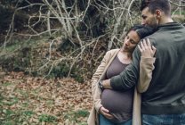 Чоловік, який обіймає вагітну жінку — стокове фото