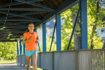 Jovem mulher correndo na ponte — Fotografia de Stock