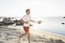Man jogging on beach — Stock Photo