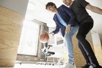 Young men playing basketball in office — Stock Photo