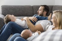 Батьки з чоловічий новонароджених і маленький син веселяться вдома — стокове фото